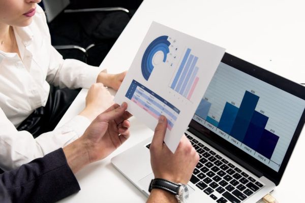 Business professionals discussing data charts and graphs in a modern office setting.